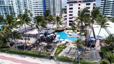 an aerial view of a resort with a pool and palm trees at Deluxe Apartments by South Florida Vacations in Miami Beach