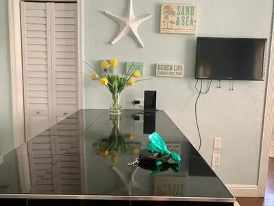 a glass table with a vase of flowers on it at Sun Sand and Love - Lovely 2 Beds, 2 Bath Condo in Miami Beach