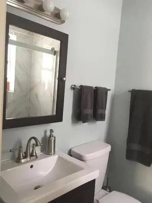 a bathroom with a sink and a toilet and a mirror at Sun Sand and Love - Lovely 2 Beds, 2 Bath Condo in Miami Beach