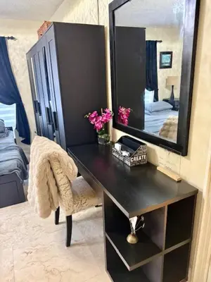 a black desk with a mirror and flowers on it at Homestay Weston Ranches in Southwest Ranches