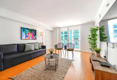 a living room with a black couch and chairs at Trendy 2BR Condo with Pool and Bay Views in Miami