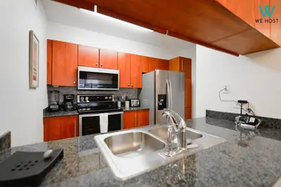 a kitchen with a sink and a stainless steel refrigerator at Amazing 3BR Condo at Brickell with City Views in Miami