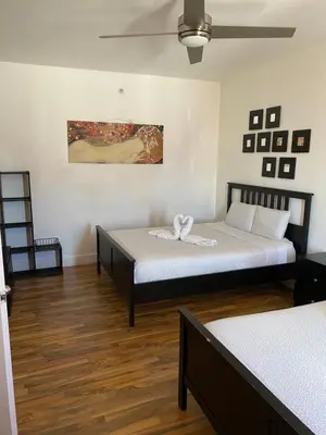 two beds in a room with wooden floors at SOBE suites in Miami Beach in Miami Beach