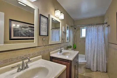 a bathroom with two sinks and a toilet and a mirror at Miami Home Outdoor Pool with Slide and Fire Pit! in Kendall