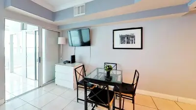 a dining room with a glass table and a tv on a wall at Castle 1131 in Miami Beach
