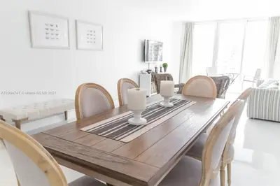 a dining room with a wooden table and chairs at DISFRUTA SUNNY ISLES OCEAn 1206 STR-02816 in Miami Beach