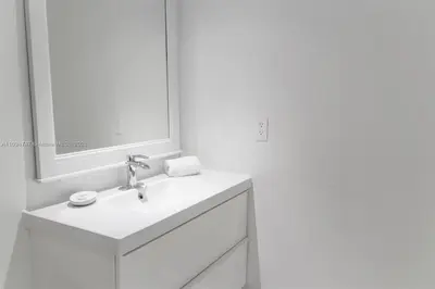 a white bathroom with a sink and a mirror at DISFRUTA SUNNY ISLES OCEAn 1206 STR-02816 in Miami Beach