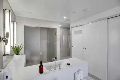 a white bathroom with a sink and a mirror at WVR Vacation Residences 1707 in Fort Lauderdale