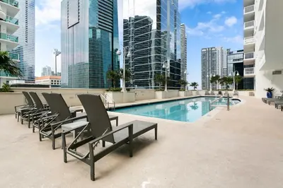 a pool on the roof of a building with chairs at Waterfront Condo with View about 6 Miles to South Beach! in Miami