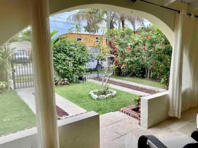 a view of a garden from a house with an archway at Entire private Beautiful 2 Bedroom plus Den House with gated front&back yard and Free parking 10min drive to Miami Beach in Miami