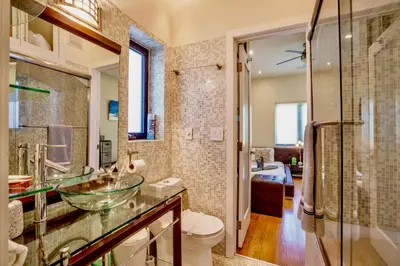a bathroom with a glass bowl sink and a toilet at Entire private Beautiful 2 Bedroom plus Den House with gated front&back yard and Free parking 10min drive to Miami Beach in Miami