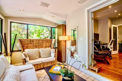 a living room with a white couch and a large window at Entire private Beautiful 2 Bedroom plus Den House with gated front&back yard and Free parking 10min drive to Miami Beach in Miami