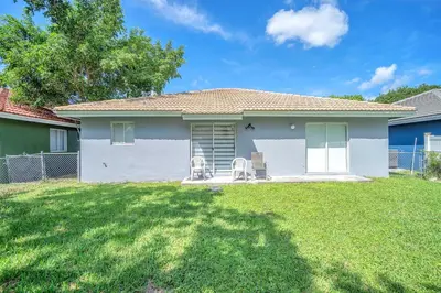 a house with two chairs in a yard at Hard Rock Hidden Gem! in Miami Gardens