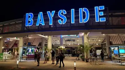 a large sign for a shopping center with people walking under it at Hard Rock Hidden Gem! in Miami Gardens