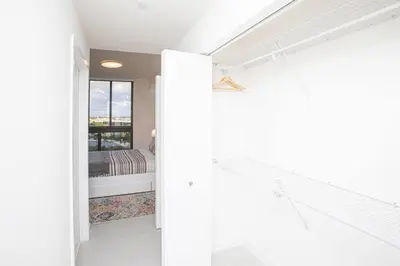 a white room with a bed and a window at Luxury Studio Apartment in Downtown Doral in Miami