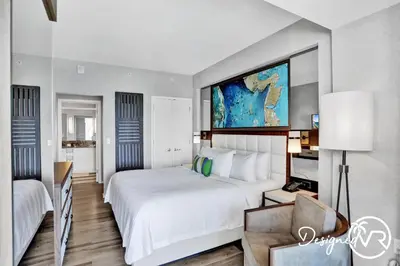 a hotel room with a large white bed and a chair at 1BR condo w hot tub gym access in Fort Lauderdale