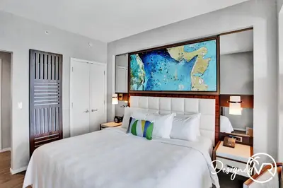 a bedroom with a large white bed with a map on the wall at 1BR condo w hot tub gym access in Fort Lauderdale