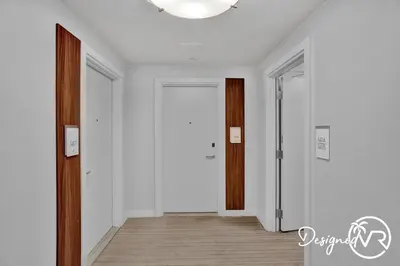 a hallway with white walls and a wooden door at 1BR condo w hot tub gym access in Fort Lauderdale