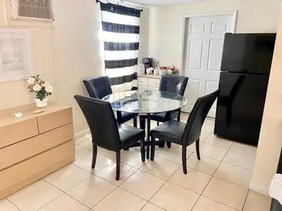 a dining room with a glass table and black chairs at Private Rooms close to Miami Airport - Free parking - 01 in Miami