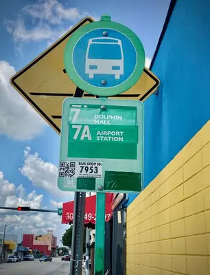 a street sign with a bus on it next to a building at Private Rooms close to Miami Airport - Free parking - 01 in Miami