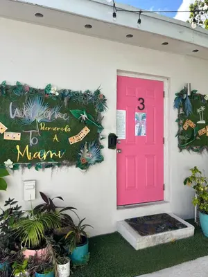 a pink door on the side of a house with plants at Stunning Little Havana Suites Close to airport, Calle Ocho, Brickell, Wynwood and the Beaches - Free Parking in Miami