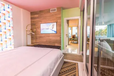 a bedroom with a bed and a tv on a wall at Boutique Suite with Huge Terrace and Rooftop Pool in Miami Beach