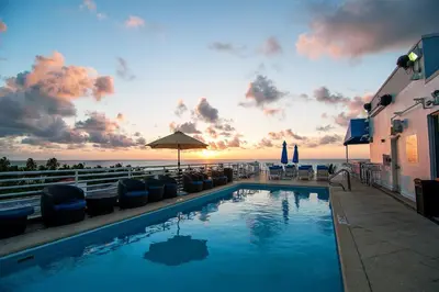 a swimming pool with a view of the ocean at sunset at Boutique Suite with Huge Terrace and Rooftop Pool in Miami Beach