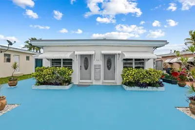 a house with a pool in front of it at Comfy BNB w/ King Bed + Work/Travel + Beach 8 Min in Hallandale Beach