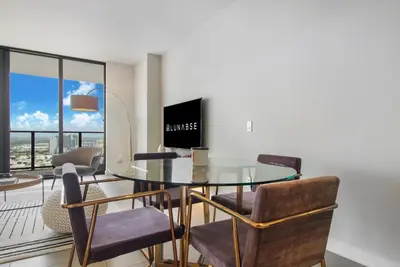 a dining room with a glass table and chairs at Lunabase Heavenly View in Miami