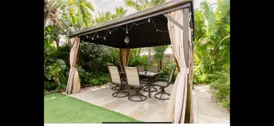a gazebo with a table and chairs in a garden at Cozy House in Fort Lauderdale