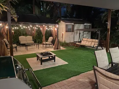 a patio with a lawn with chairs and a table at Cozy House in Fort Lauderdale