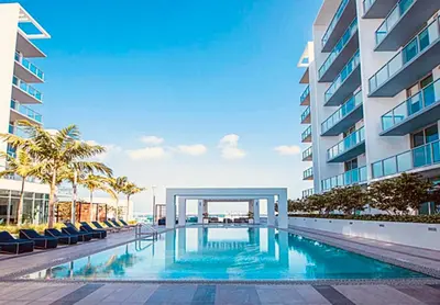 a swimming pool in front of a building at Sleek 2BD 2BA Condo In Miami Design District in Miami
