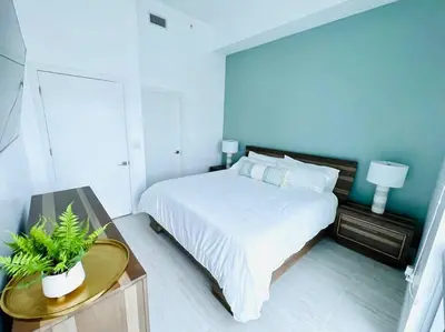 a bedroom with a bed and a table with a plant at Sleek 2BD 2BA Condo In Miami Design District in Miami