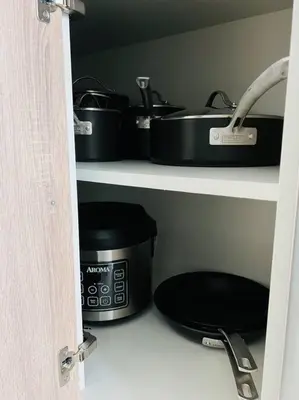 a kitchen pantry with pots and pans on shelves at Sleek 2BD 2BA Condo In Miami Design District in Miami