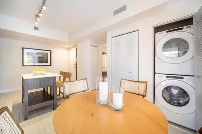 a kitchen with a table and a washing machine at Tucker at Palmer Dadeland Miami in Miami
