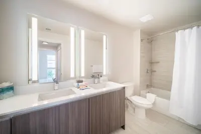a bathroom with a sink and a toilet and a mirror at Tucker at Palmer Dadeland Miami in Miami