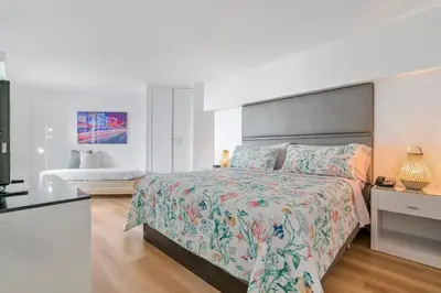 a bedroom with a large bed with a floral bedspread at Avi Lux Stay in Fort Lauderdale