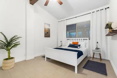 a white bedroom with a bed and a potted plant at CocoBay 2BR Condos Near Beach, Galleria Mall, Wilton Manors, Cruise Port in Fort Lauderdale