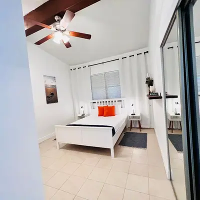a white bedroom with a bed and a ceiling fan at CocoBay 2BR Condos Near Beach, Galleria Mall, Wilton Manors, Cruise Port in Fort Lauderdale