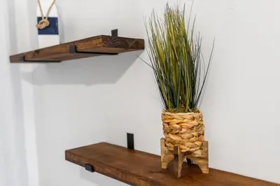 a vase with grass in it sitting on a wooden shelf at CocoBay 2BR Condos Near Beach, Galleria Mall, Wilton Manors, Cruise Port in Fort Lauderdale
