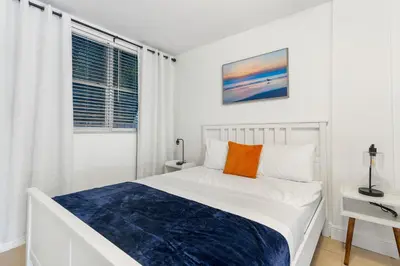 a white bedroom with a bed and a window at CocoBay 2BR Condos Near Beach, Galleria Mall, Wilton Manors, Cruise Port in Fort Lauderdale