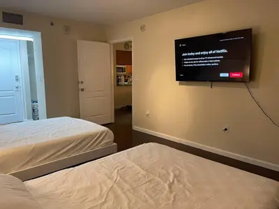 a bedroom with two beds and a flat screen tv on the wall at Rooftop Pool with Water View in Miami