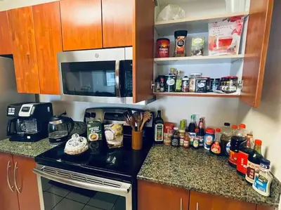 a kitchen with a counter with a microwave and a stove at Rooftop Pool with Water View in Miami