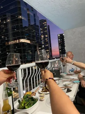 a group of people sitting at a table with wine glasses at Rooftop Pool with Water View in Miami