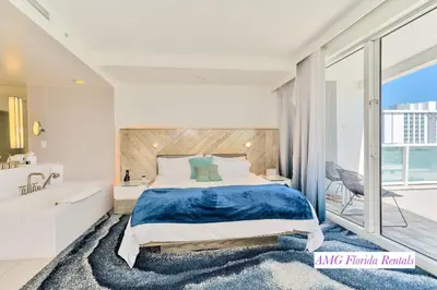a bedroom with a large bed and a tub and a sink at Stylish 1 BR at Fort Lauderdale in Fort Lauderdale