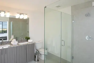 a bathroom with a toilet and a glass shower at Luxury 1BD/1BT Apartment in Downtown Doral in Miami