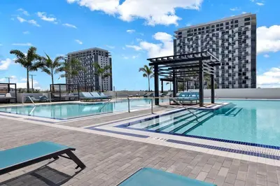 a swimming pool with a picnic table next to a building at Luxury 1BD/1BT Apartment in Downtown Doral in Miami