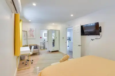 a room with a bed and a desk and a tv at Beautiful Casita with King Bed and private patio Close to Calle 8, MIA Airport, Coral Gables in Miami