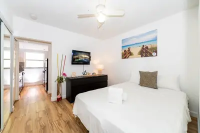 a bedroom with a white bed and a ceiling fan at South Beach Apartments in Miami Beach