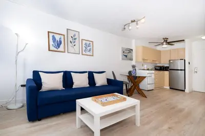 a living room with a blue couch and a table at South Beach Apartments in Miami Beach
